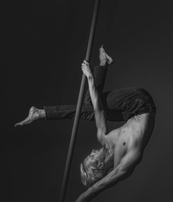 A man performing a controlled strength exercise in a modern, minimalist gym.